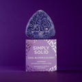 Cool Blond and Glossy Solid mit Verpackung vor einem lilafarbenen Hintergrund
