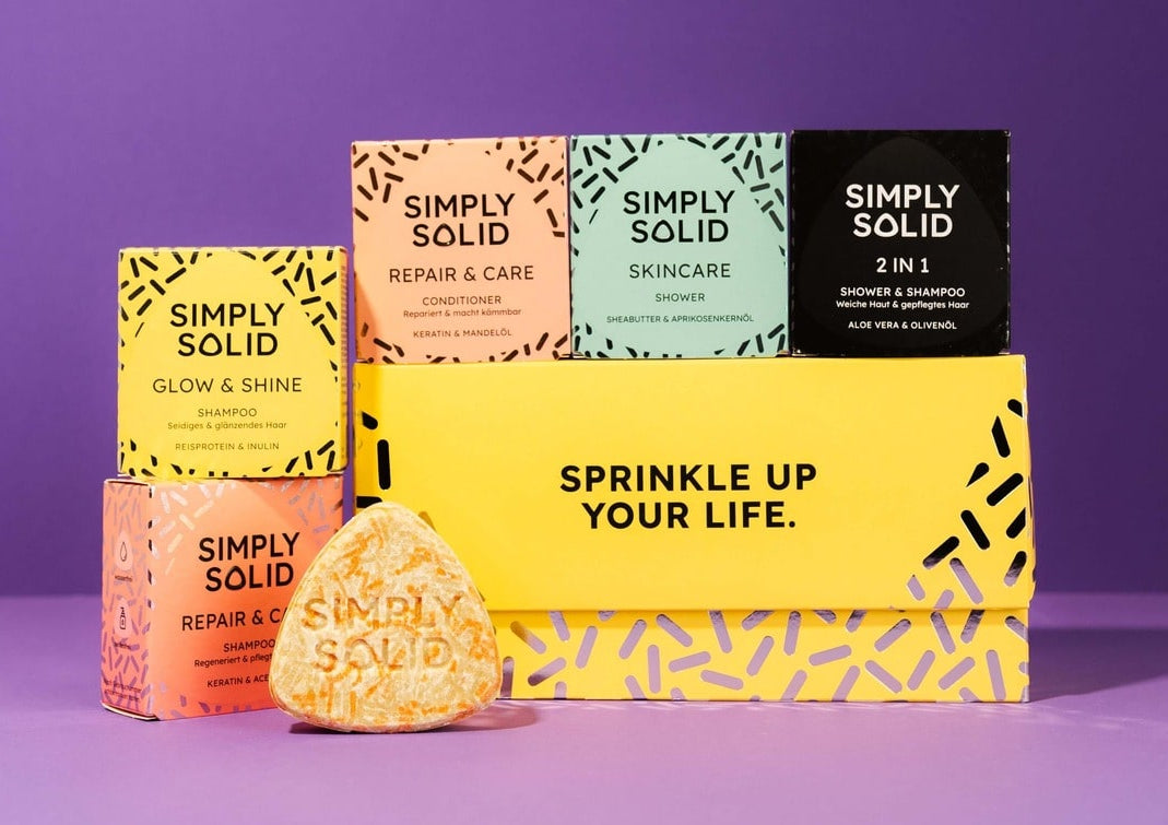 Simply Solid Geschenkset mit allen Solids auf dem Deckel sowie davor und Travelbox vor violettem Hintergrund.