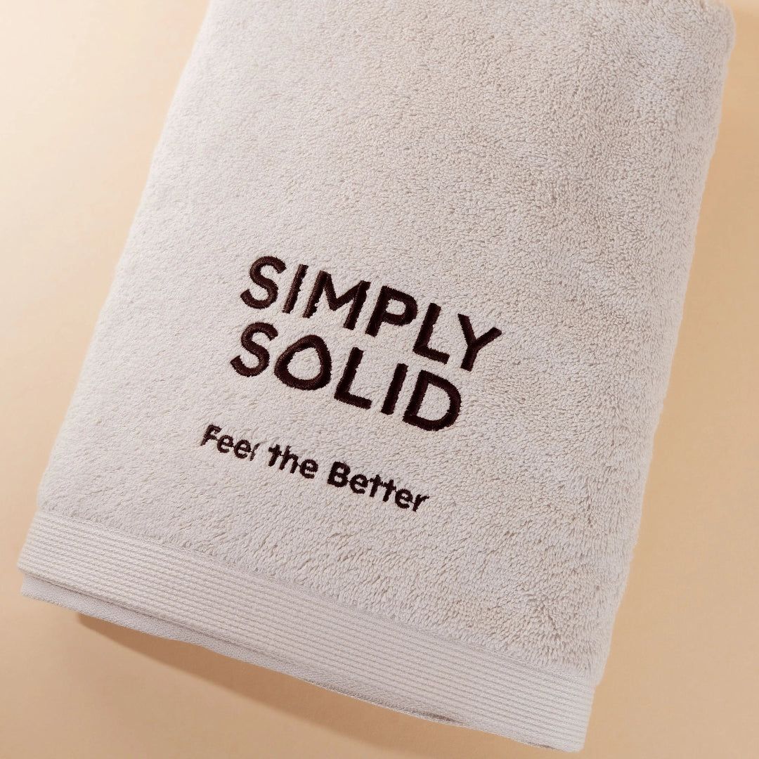 Simply Solid Duschtusch aus 100% Baumwolle (Oeko-Tex zertifiziert) vor einem beigen Hintergrund
