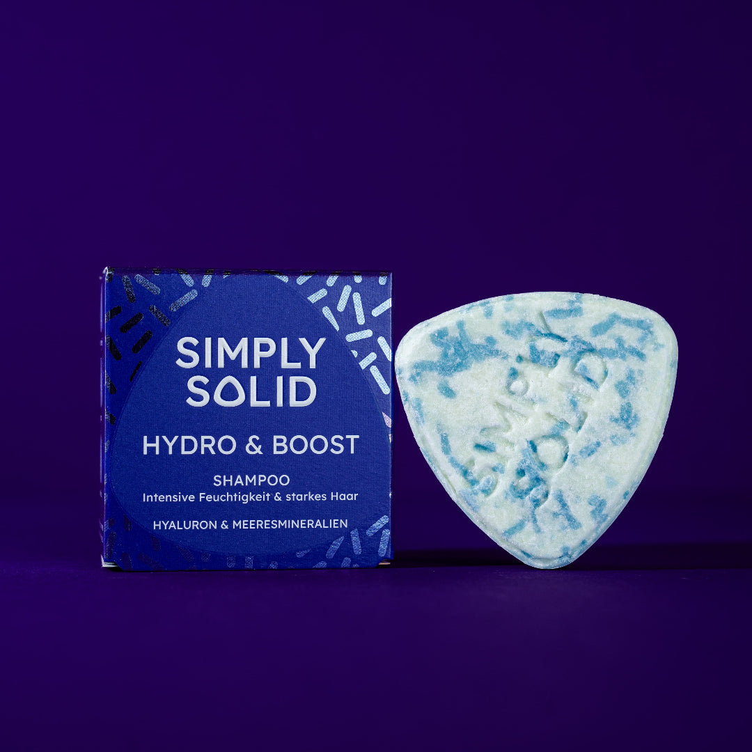 Hydro and Boost Solid mit Verpackung vor einem lilafarbenen Hintergrund