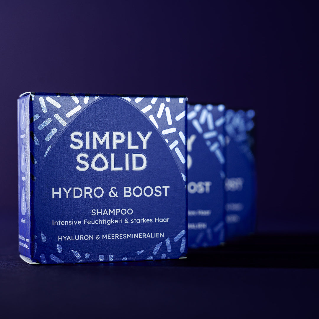 Hydro and Boost Solid Verpackungen aufgereiht vor einem lilafarbenen Hintergrund